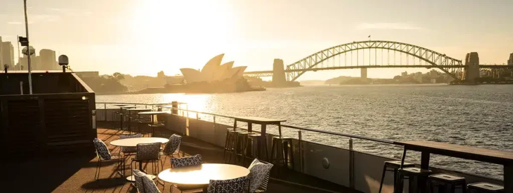 a table and chairs on a deck overlooking a bridge and a city