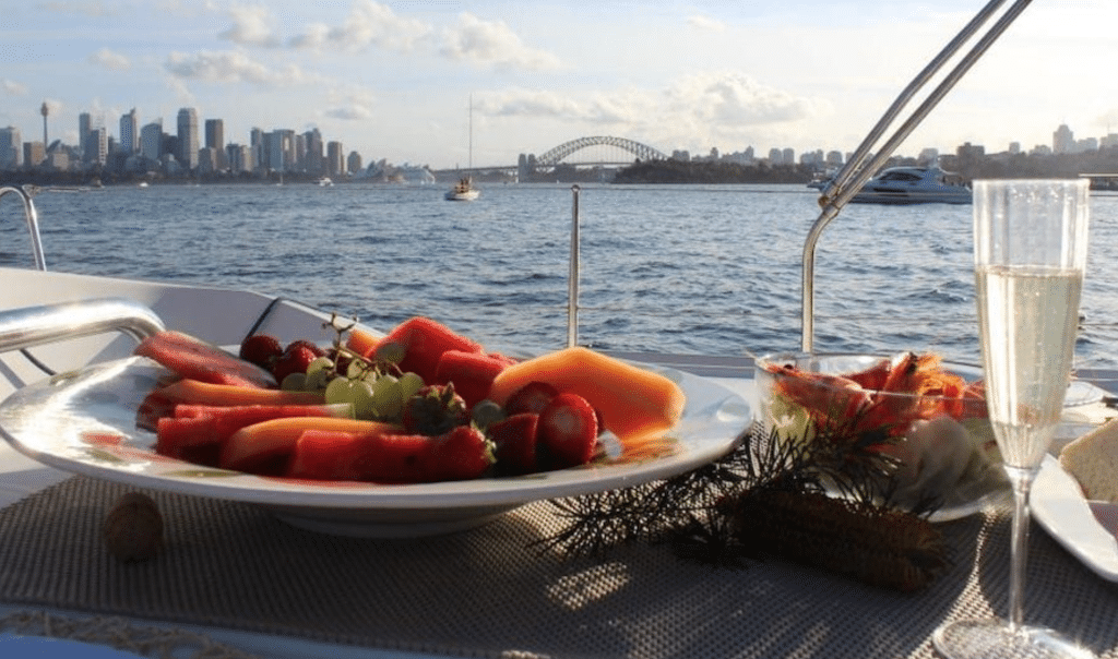 a plate of fruit and a drink on a boat