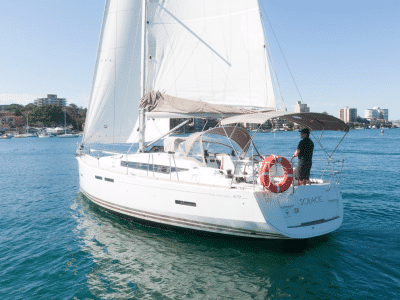 a man standing on a sailboat solace in the water