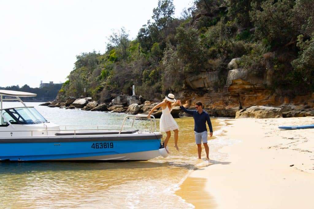 couple getting off a boat to enjoy beach on sunny day