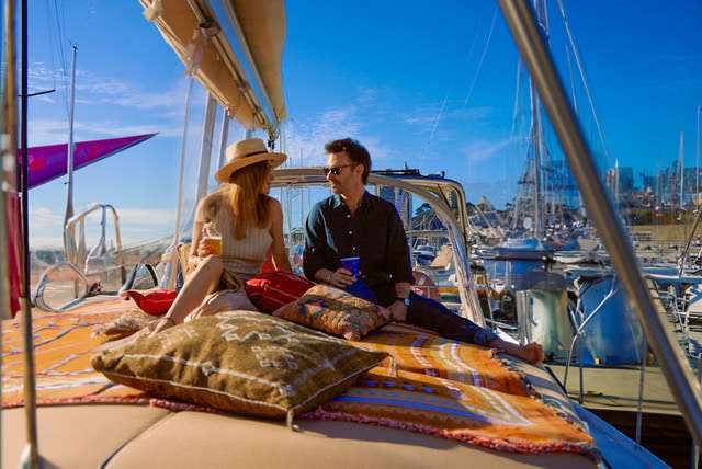 Couple at the bow of a Sydney Harbour charter boat at sunset