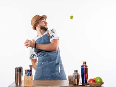 front view male bartender front bar desk playing with fruits white wall bar alcohol night job fruit drink club